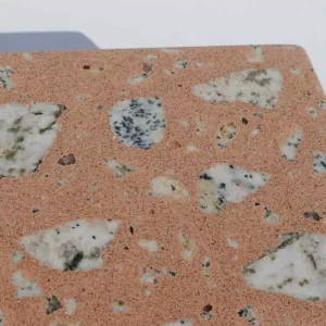 Concrete terrazzo finish sample with natural stone aggregates. Its coral colour concrete with real granite and marble aggregates, using big chunky and smaller clippings.