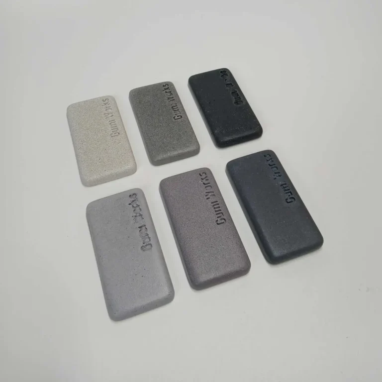 0ff-white, grey, and black shades concrete colour samples group in focus on white background.