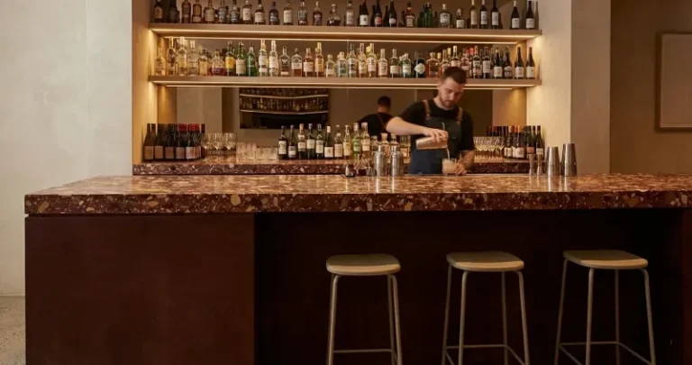 Artisan concrete bar top with deep earth tones and polished finish for a luxury restaurant.