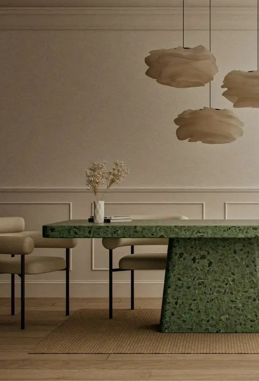 Hand-cast green terrazzo concrete dining table with granite aggregate in soft minimalist London interior.