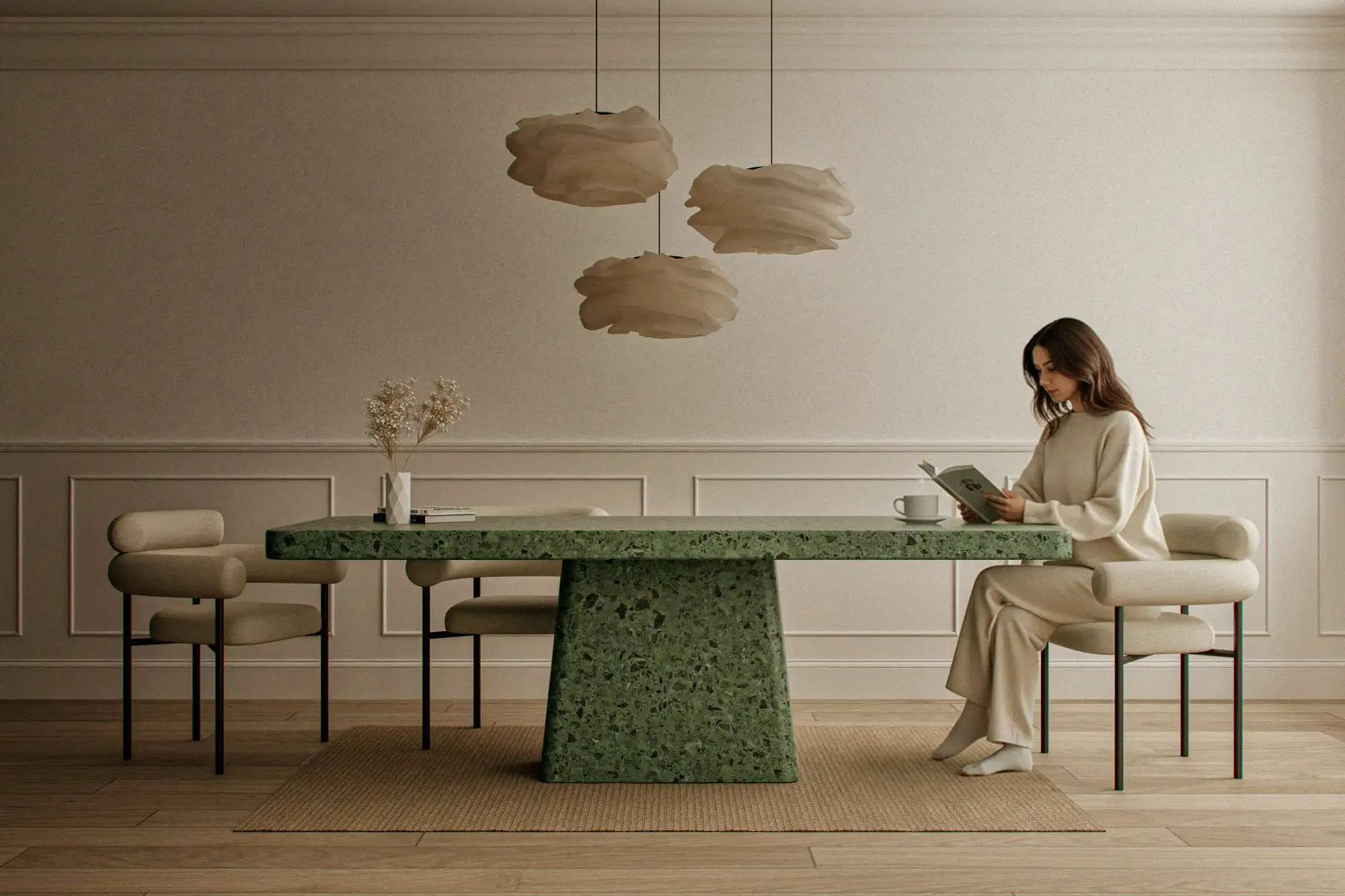 Woman reading at a sculptural emerald green terrazzo concrete dining table with marble and granite aggregate in a minimalist London interior.
