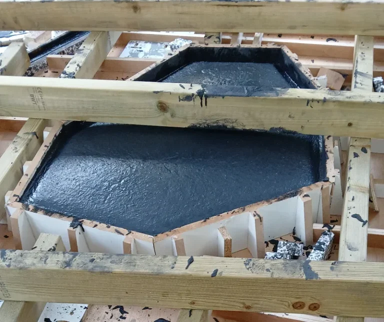 Hand-casting high-performance GFRC concrete into a custom mould for a monolithic gym interior statement piece.