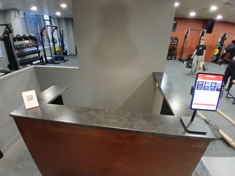 Front view of a seamless J-shaped concrete reception desk worktop, cast in one piece for a commercial London fit-out.