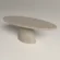 concrete-dining-table-oval-scultural-pedestal-base-uk-handmade Oval dining table with pedestal base. Cross view of table, made with gfrc concrete, in sand colour. Has modern style that will suit modern minimalist to contemporary UK interiors.