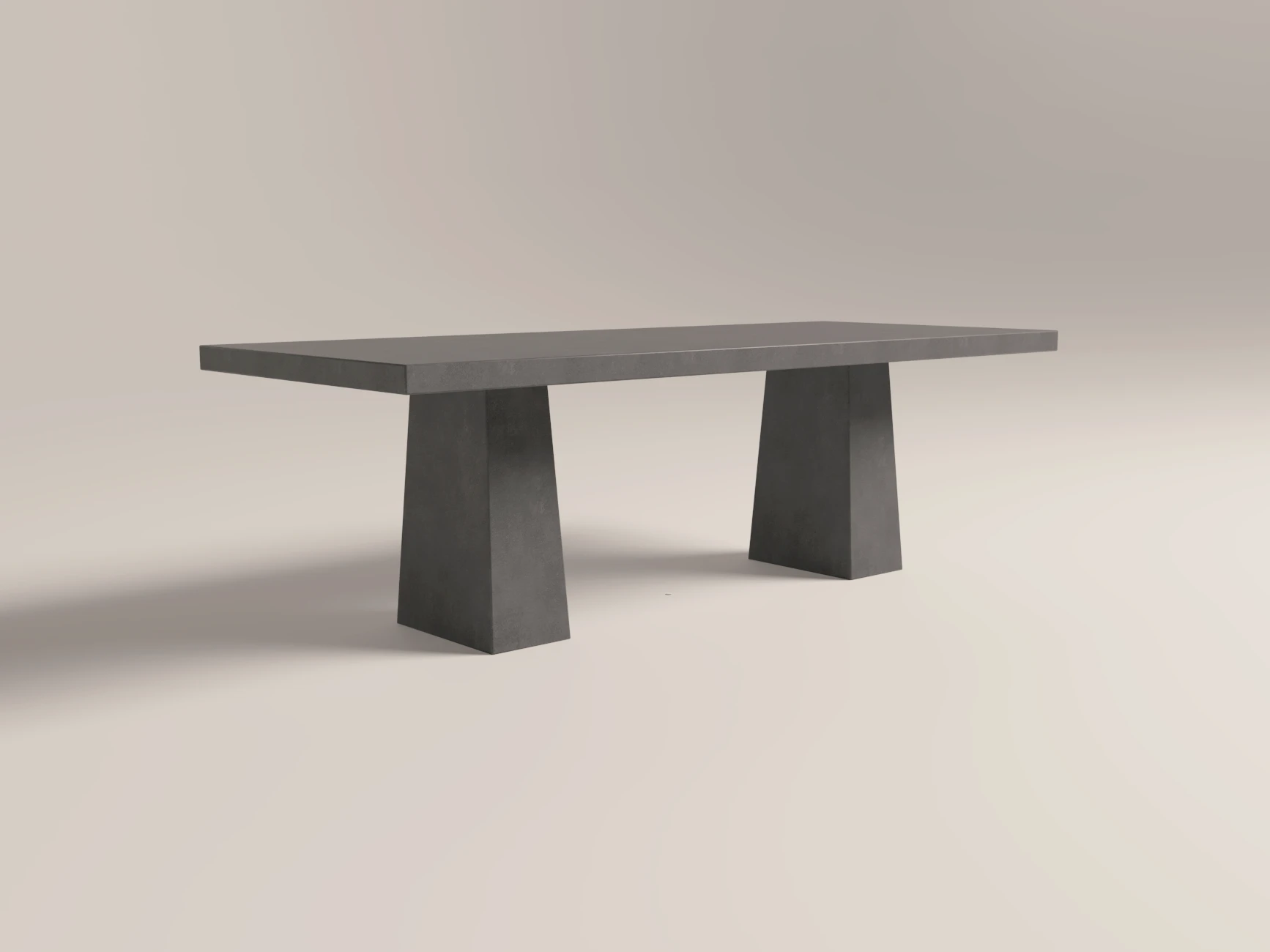 concrete-dining-table-rectangular-double-scultural-pedestal-base-lower-back-uk-london Bespoke concrete dining table, rectangle tabletop with architectural trapezoid double pedestal base. Cross angle view of table, finished in dark grey colour polished concrete.