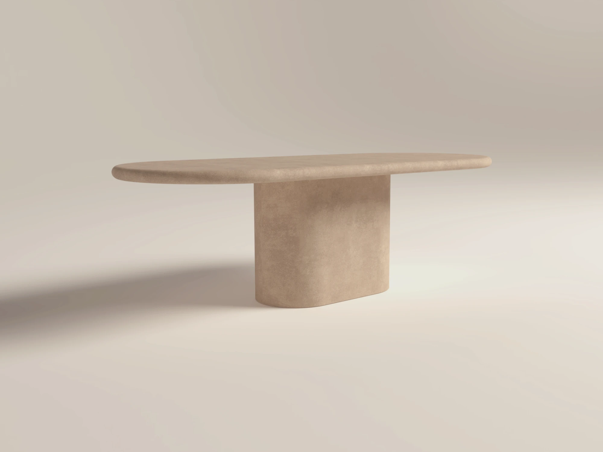 Pill-shaped concrete table with matching pill shape pedestal base, finished in clay colour polished concrete. A lower-back shot of the table in London studio workshop.
