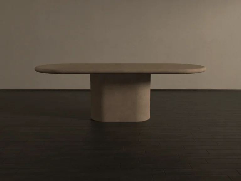Pill-shaped, round and soft edge pedestal base dining table. racetrack shaped top has a matching pedestal base, finished in clay colour polished concrete. shown in soft light side view shot in London Studio UK.