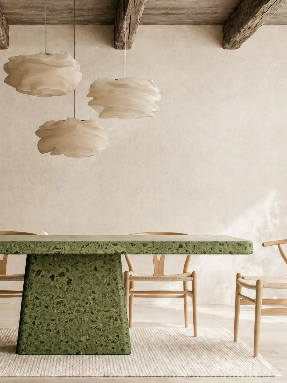Hand-cast green terrazzo concrete dining table with granite aggregate in soft minimalist London interior.