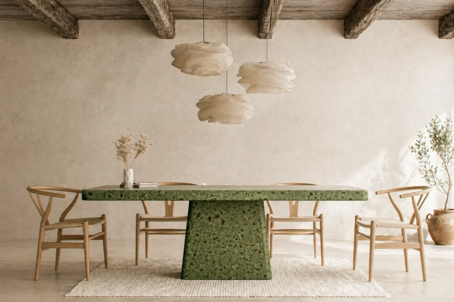 Woman reading at a sculptural emerald green terrazzo concrete dining table with marble and granite aggregate in a soft minimalist London interior.