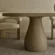 Soft-modern-scultural-dining-table-polished-concrete-high-end-uk Close-up still-life view of a hand-finished concrete tabletop and sculptural, organic-form pedestal base. Concrete dining table shown in soft modern, natural decor UK interior.