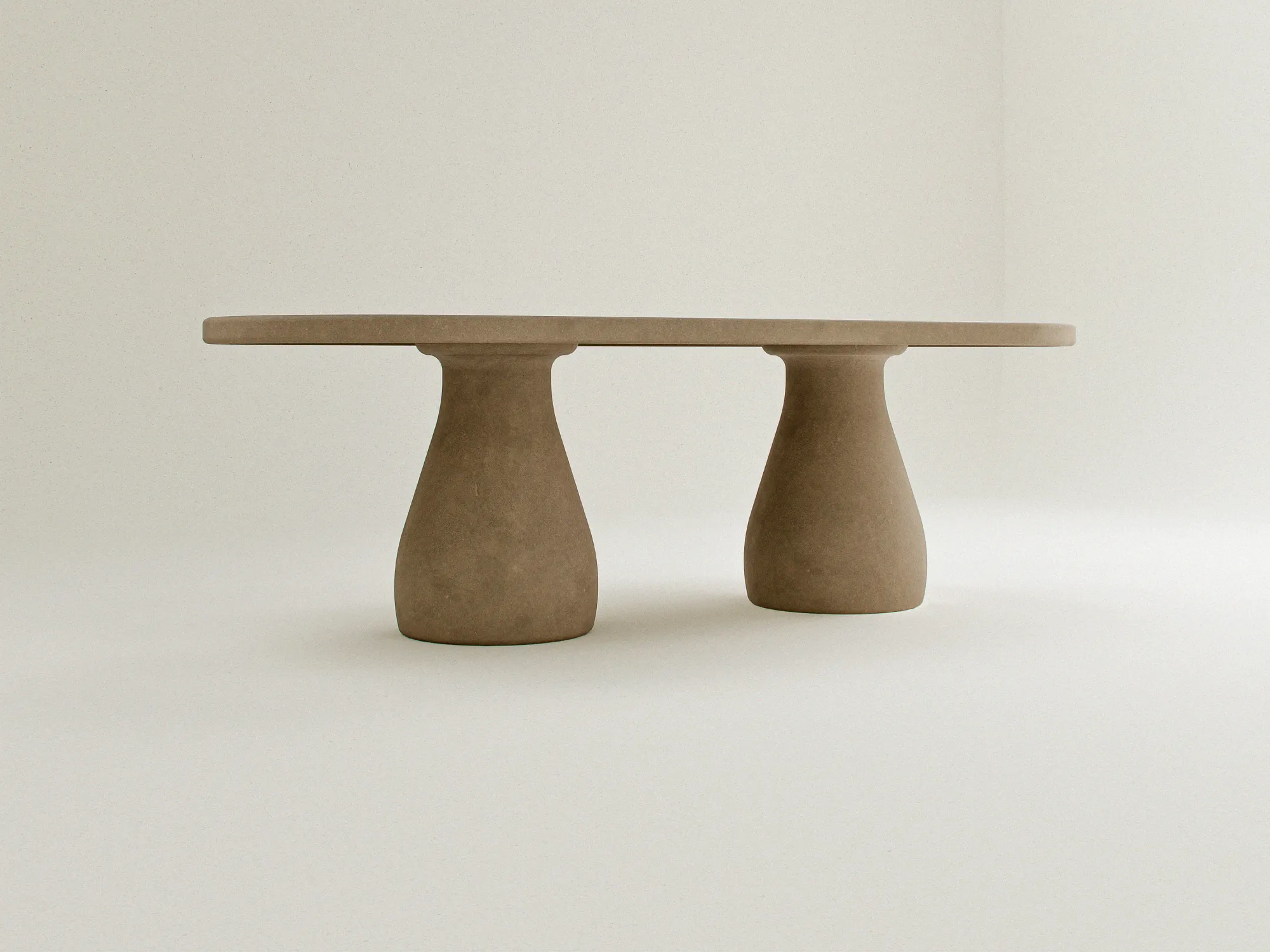 concrete-scultural-table-mediterranean-decor-uk-interior-outdoor-living A high-end, Sculptural Pedestal Concrete Dining Table. Cross-view studio shot of the concrete table on white background.